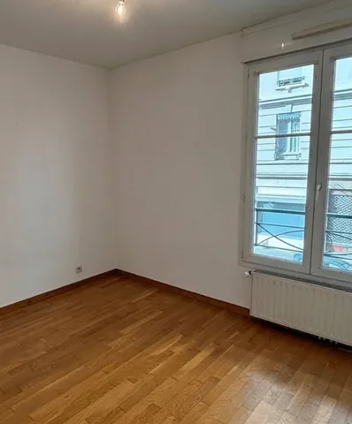 Chambre avec parquet et grande fenêtre