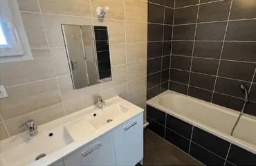 Salle de bains avec baignoire et double vasque