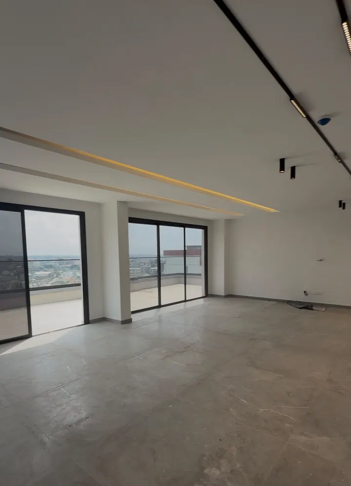 Le séjour et ses baies vitrées — appartement à Abidjan