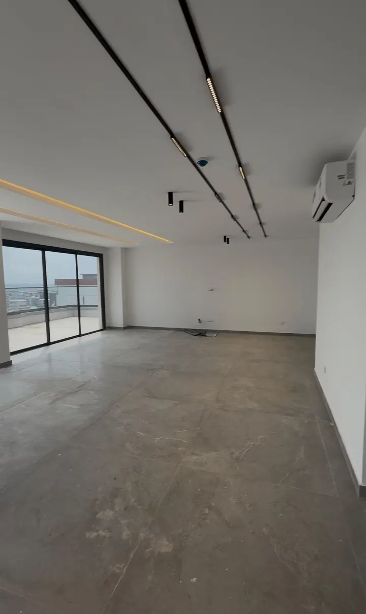 Le séjour, vue vers la terrasse et la ville — appartement à Abidjan